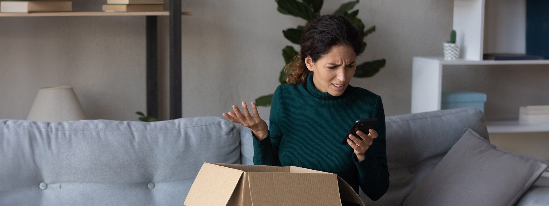 Woman opening a package looking confused at her phone