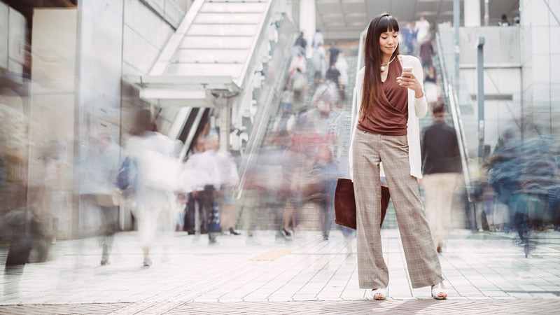 Woman standing in mall looking at her smartphone